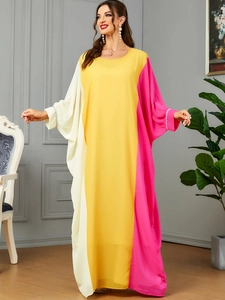 Detail of elegant color-block caftan dress showing pearl embellishments on sleeves