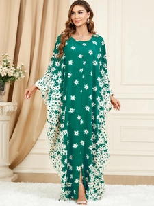 Detail of green kaftan dress featuring white daisy floral prints and batwing sleeves