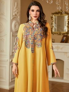 Nahaufnahme des gelben Kaftan-Kleides mit aufwendiger Paisley-Stickerei und Pailletten