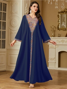 Close-up of ethnic V-neck embroidery and sequins on this dark blue elegant kaftan dress