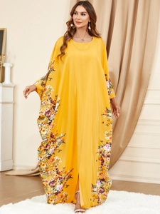 Détail de l'imprimé floral sur robe kaftan jaune à manches chauve-souris et coupe ample
