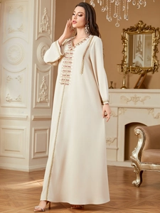 Detailed beadwork and embroidery on an elegant cream Turkish kaftan dress with V-neck