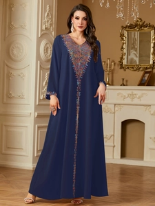 Detail of colorful ethnic embroidery and sequins on navy blue kaftan maxi dress