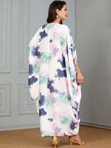 Detailansicht des abstrakten Aquarelldrucks auf einem weißen Kaftan mit Fledermausärmeln