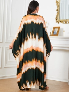Back view of loose kaftan maxi dress with orange and green zigzag print in elegant room