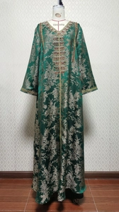 Detailed view of dark green satin Kaftan with golden floral jacquard and beaded neckline