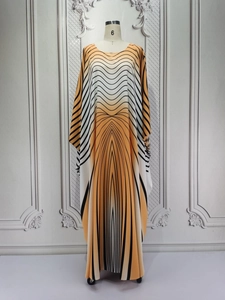 Detail of elegant kaftan maxi dress with orange and black geometric pattern on a mannequin