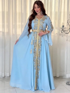 Détail d'un caftan bleu clair avec broderies dorées et ceinture ornée de haute qualité
