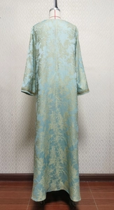 Detail of light blue jacquard evening gown showing intricate gold floral embroidery on cuffs