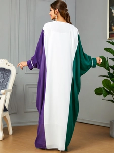 Detail view of purple, white, and green color-block gown with sequined cuffs and batwing sleeves