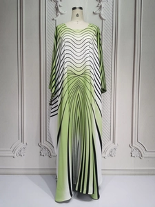 Detail of green and white gradient maxi dress with black wavy stripes and batwing sleeves