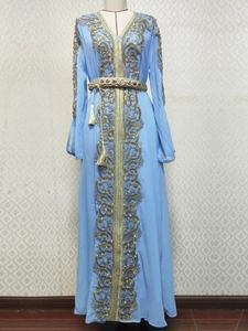 Détail du caftan bleu ciel avec broderie dorée complexe et ceinture à glands