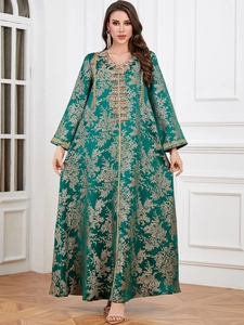 Detailed view of dark green Kaftan dress with golden embroidery and beaded neckline