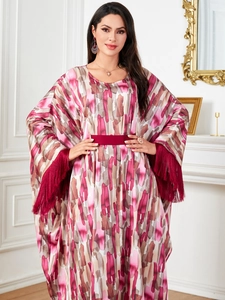 Detail of batwing sleeve kaftan dress with long fringes and colorful abstract print