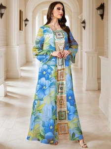 Détail d'une robe caftan à fleurs bleues avec un panneau vertical à paillettes brillantes