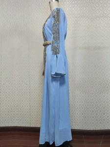 Vue détaillée des broderies dorées sur une robe de soirée caftan bleu clair