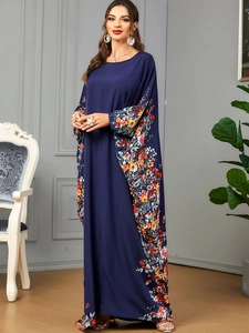 Vue détaillée des imprimés floraux sur une robe caftan bleu foncé à manches chauve-souris