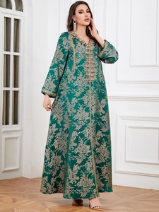Close-up of green Kaftan dress with golden floral embroidery and intricate beadwork detail