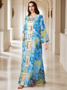 Détail de broderie de paillettes géométriques sur une robe Kaftan fleurie bleue