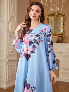 Dettaglio dell'abito floreale azzurro con stampe rosa e viola e texture levigata