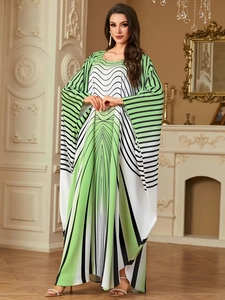 Detail of elegant batwing sleeve maxi dress with green and white geometric print