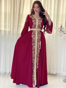 Détail du caftan marocain bordeaux avec broderies dorées lourdes et ceinture assortie