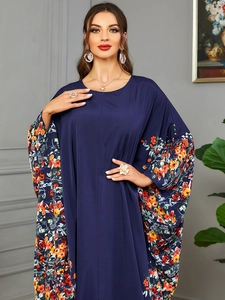 Détails des manches chauve-souris à imprimé floral orange sur une robe caftan bleu foncé