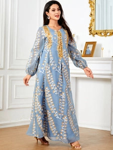 Détails de la robe de soirée bleu clair avec broderies pailletées dorées et motifs