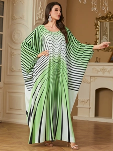 Close-up of green and white gradient kaftan dress with dynamic black stripe patterns