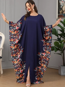 Détail de la robe caftan à manches chauve-souris, tissu bleu marine et fleurs