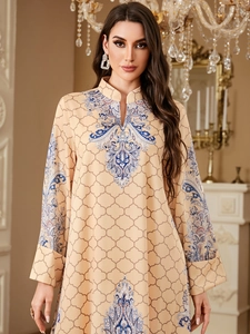 Detail of ethnic paisley embroidery on luxury long-sleeve kaftan dress with wave print