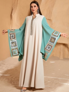 Detail of geometric sequin embroidery on wide sleeves of a long kaftan dress