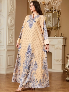 Detail of elegant orange long-sleeve dress with Persian print and satin texture