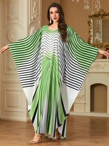 Detail of elegant green and white wavy print on a long kaftan dress with batwing sleeves