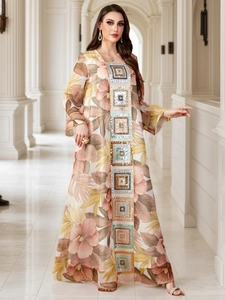 Détail de broderie de paillettes et imprimé fleuri sur la robe abaya bohème à manches longues
