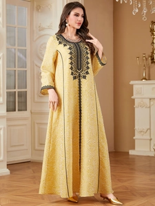 Elegant yellow embroidered kaftan dress with long sleeves for women in vintage room