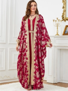 Close-up of dark red kaftan with intricate gold floral embroidery and lace trim details