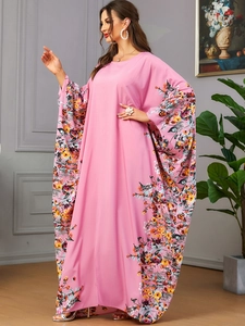 Détail d'une robe caftan rose à imprimé floral avec manches chauve-souris et coupe ample