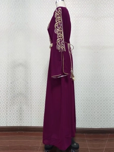 Détails de la broderie à paillettes dorées sur les manches et ceinture à glands du caftan