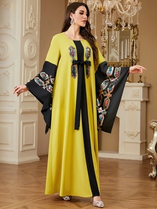 Detail of sequin geometric embroidery on yellow kaftan dress with flared sleeves