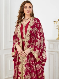 Detailed close-up of dark red Abaya with intricate gold floral embroidery and lace trim