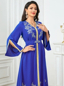 Detail of royal blue kaftan with gold floral embroidery and hand-sewn beadwork accents