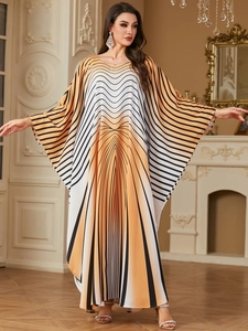 Detail of elegant kaftan dress featuring orange gradient geometric stripes and batwing sleeves