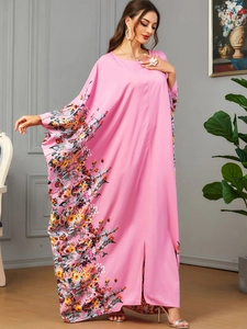 Détail d'une robe maxi rose à manches chauve-souris avec imprimé fleuri et fente avant