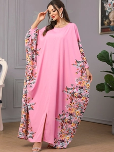 Détail de la robe longue rose à manches chauve-souris et imprimés floraux élégants