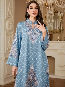 Detail of light blue long-sleeved dress with white geometric patterns and ethnic trim
