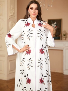 Detail showing the stand-up collar and purple floral embroidery on white kaftan dress
