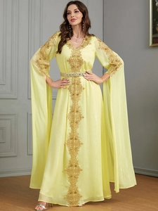 Details der goldenen Blumenstickerei auf gelbem Kaftan-Kleid mit Metallgürtel