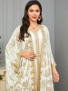 Detailed close-up of intricate gold embroidery on a white Moroccan kaftan dress