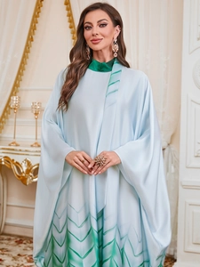 Detail of elegant light blue satin Jalabiya with green leaf gradient patterns and batwing sleeves